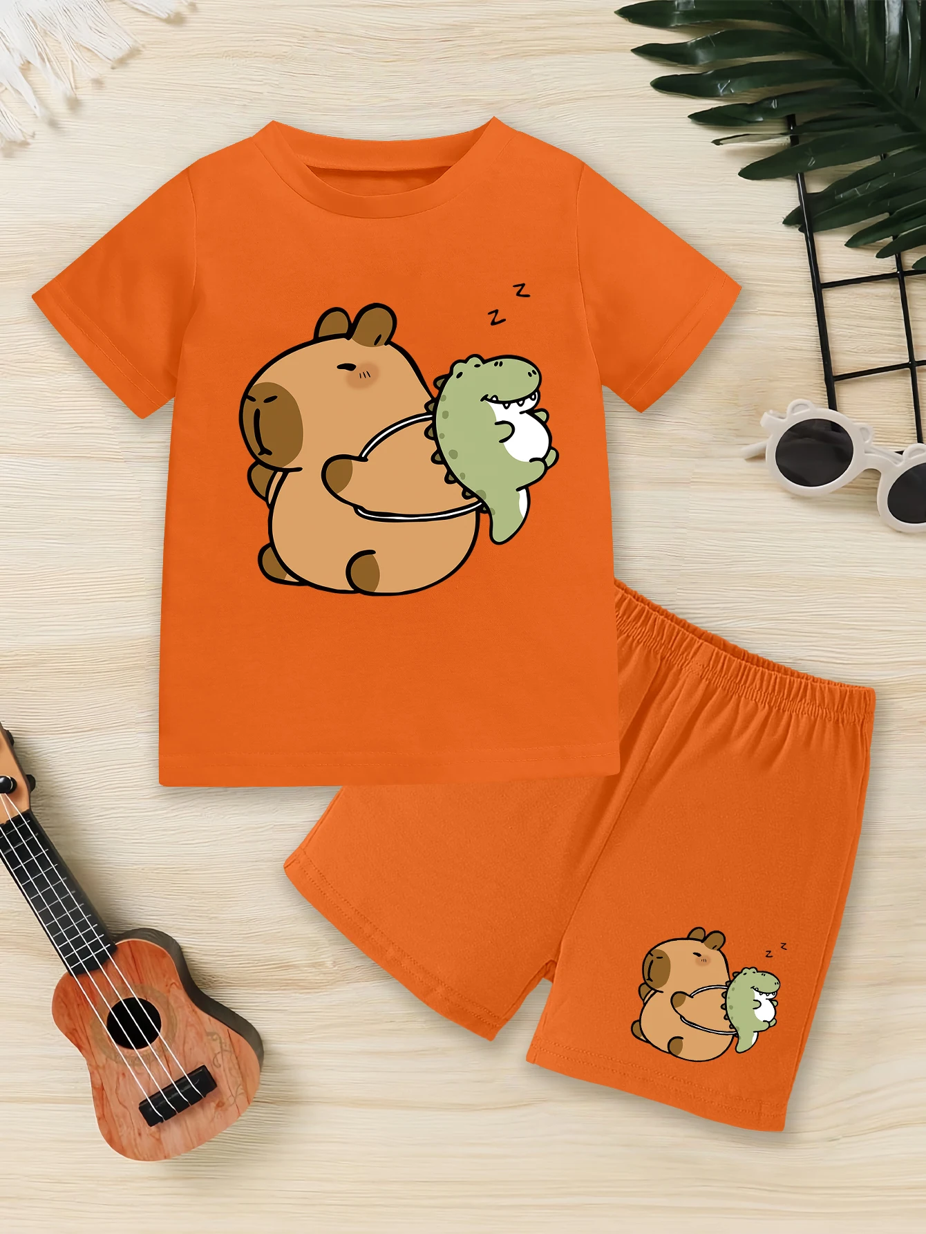 

Комплект из 2 предметов: летний комплект для мальчиков с принтом капибары и динозавра, футболка и шорты