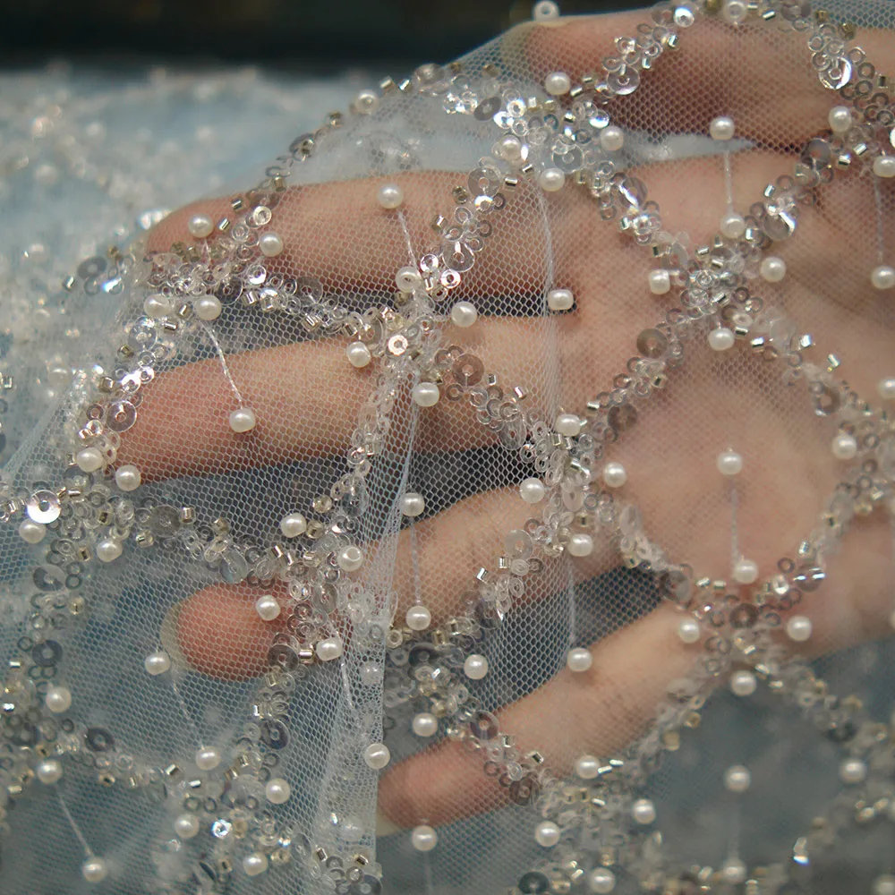 Il nuovo tessuto di pizzo azzurro 2025 con ricami di perline è delicato e romantico, adatto per matrimoni e feste