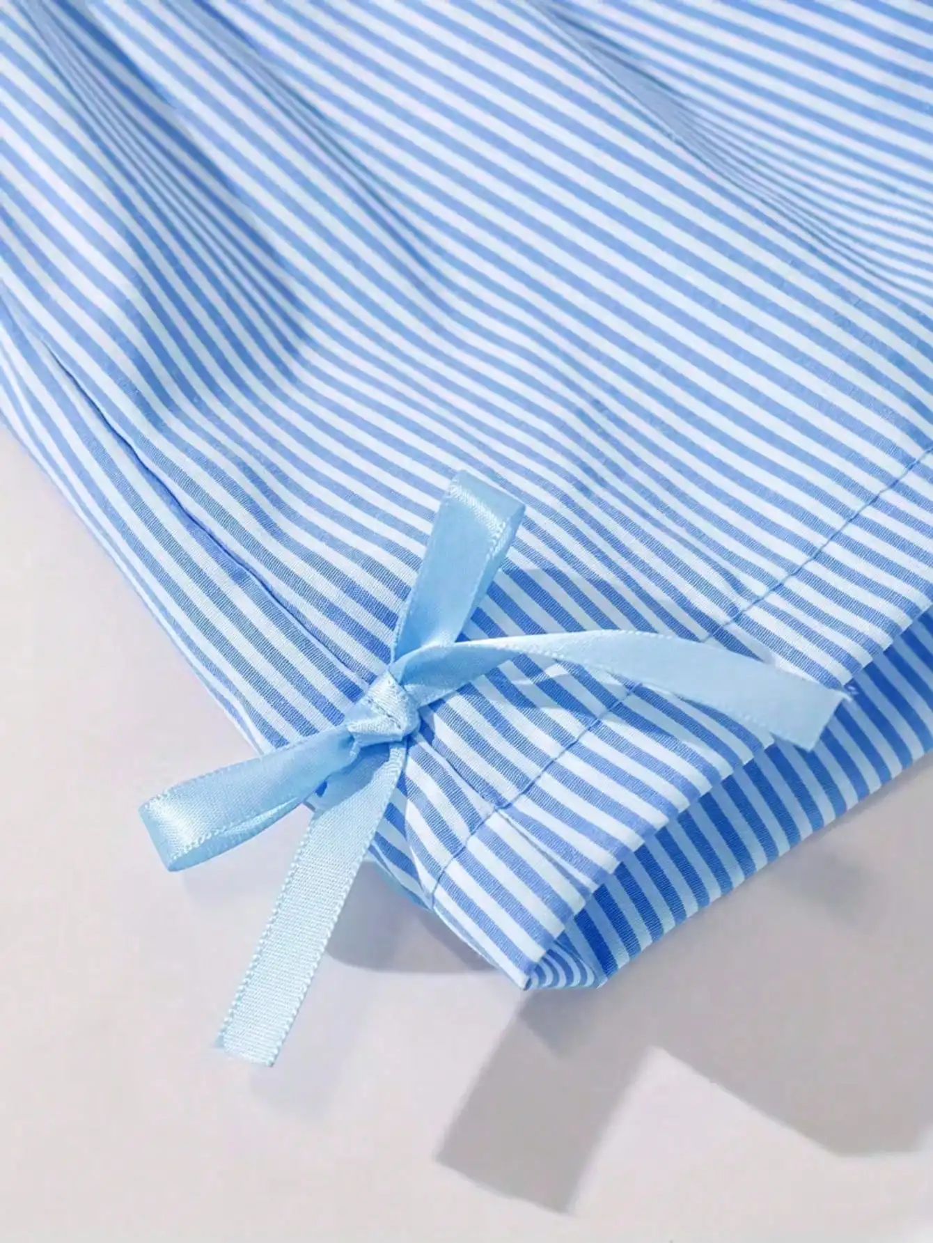 Modisches zweiteiliges Set für Mädchen: rosa-weiß gestreifter Rundhalspullover mit Schnürung, Schleife und Rüschenrand + rosa gestreifte Schmetterlings-Shorts. – Detail 18