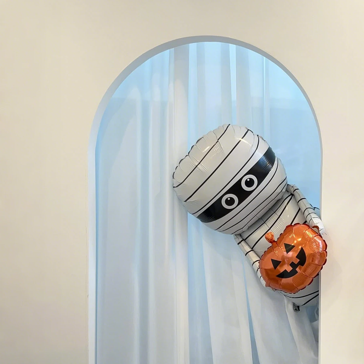 مومياء تحمل بالون من رقائق الألومنيوم اليقطين باللون الأبيض والبرتقالي لعناصر رعب لتزيين حفلات الهالوين