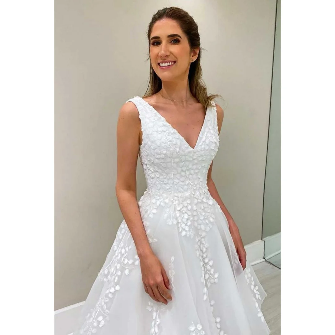 ชุดแต่งงานคอวีแขนกุด ดีไซน์หรูหรา ประดับด้วยลูกไม้ระบายเป็นชั้นๆ ชายกระโปรงไม่สมมาตร พร้อมชายกระโปรงยาวแบบคอร์ทเทรน เหมาะสำหรับงานแต่งงานหรืองานพรอม