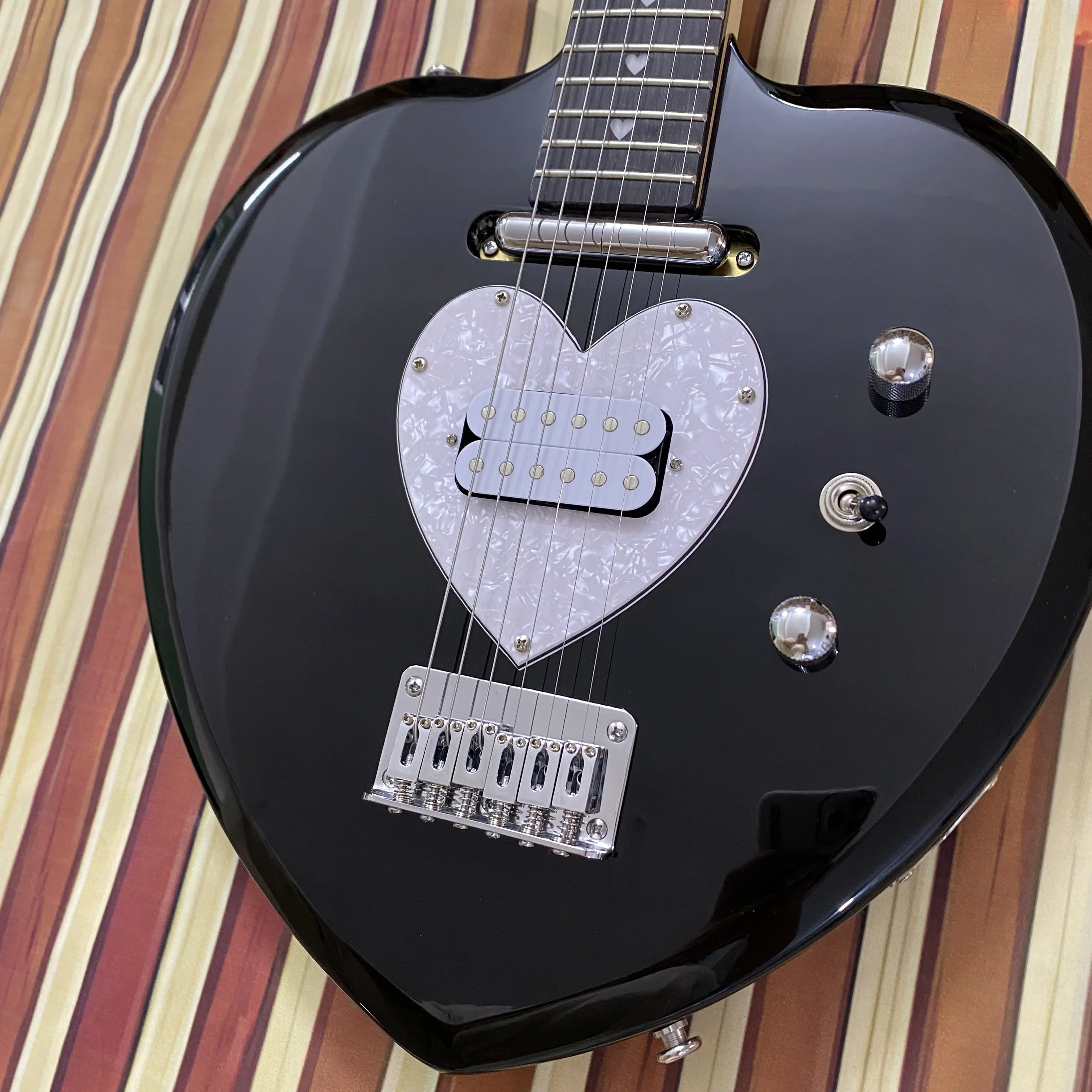 Vicers Guitarra elétrica requintada em forma de coração. Corpo em mogno. Fretboard de jacarandá. Pescoço de bordo. 22 trastes. Ferragens cromadas.