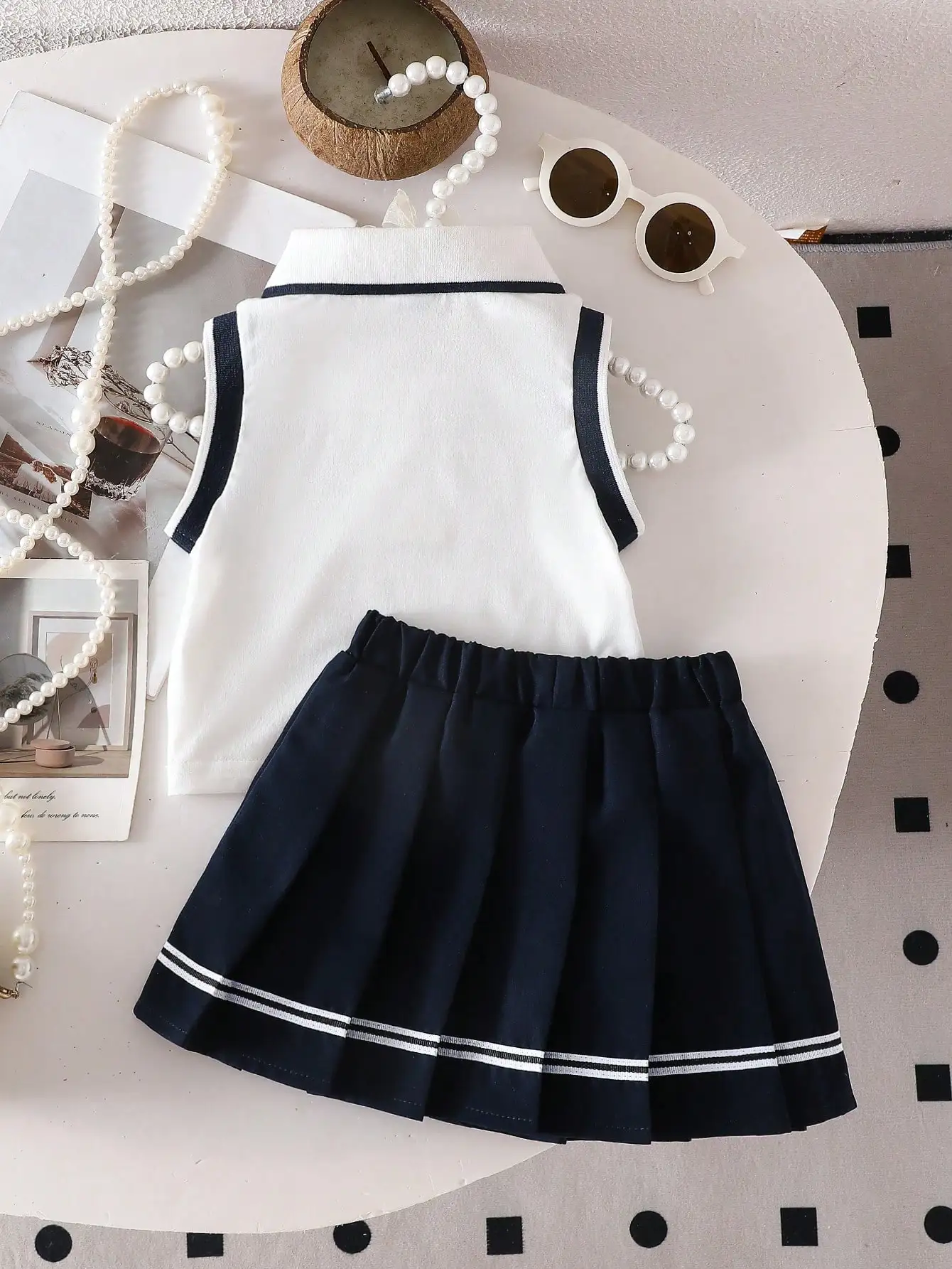 Zweiteiliges Set für Babys: ärmelloses Oberteil mit herzbesticktem POLO-Kragen und gewebter, lässiger, plissierter kurzer Rock im süßen und coolen Stil. – Detail 2