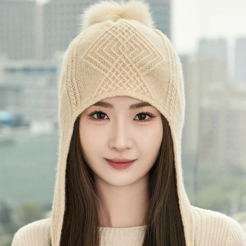 قبعة كرة شعر عصرية للسيدات شتوية سميكة 100% من الكشمير الخالص محبوكة بلون سادة قبعة حماية للأذن دافئة ومقاومة للرياح