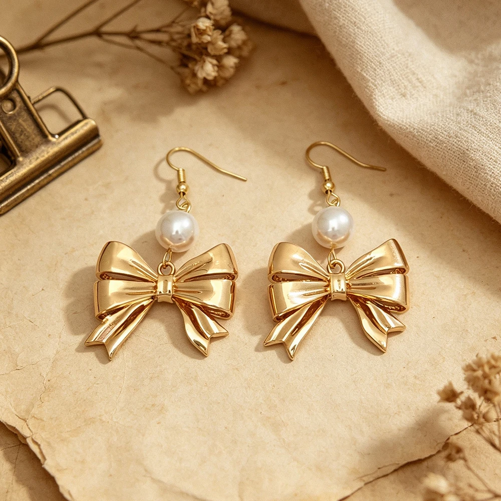 Three-dimensional metal bow paired with round faux pearls, in gold and silver tones, simple and vintage, with a graceful dangle, suitable for both work and dates.