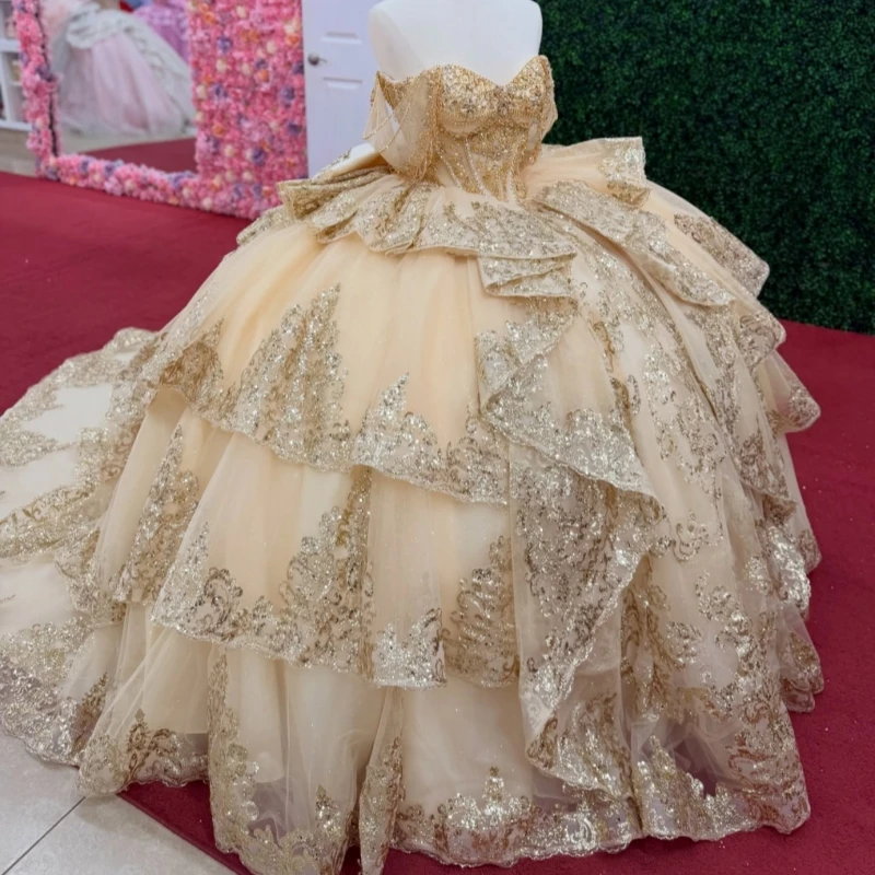 

Champagne Shiny Ball Gown Quinceanera Dresses 2026 Gold Applique Lace Beading Crystal Bow Corset Tull Off Shoulder Sweet 16