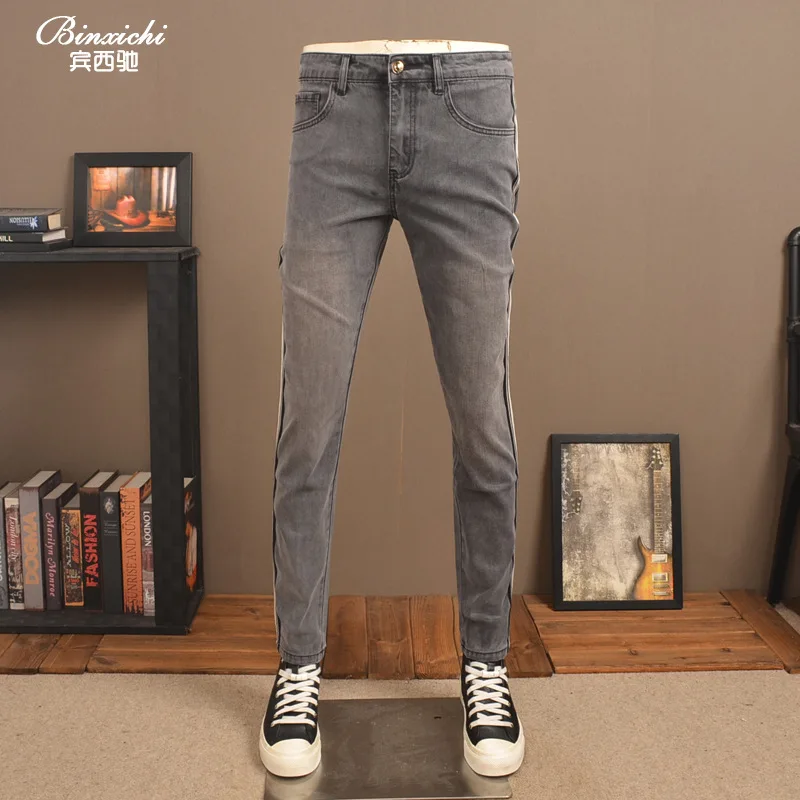 Celana jeans pria 2025 model baru trendi high-end elastis potongan ramping dengan hiasan pita rajutan bergaris