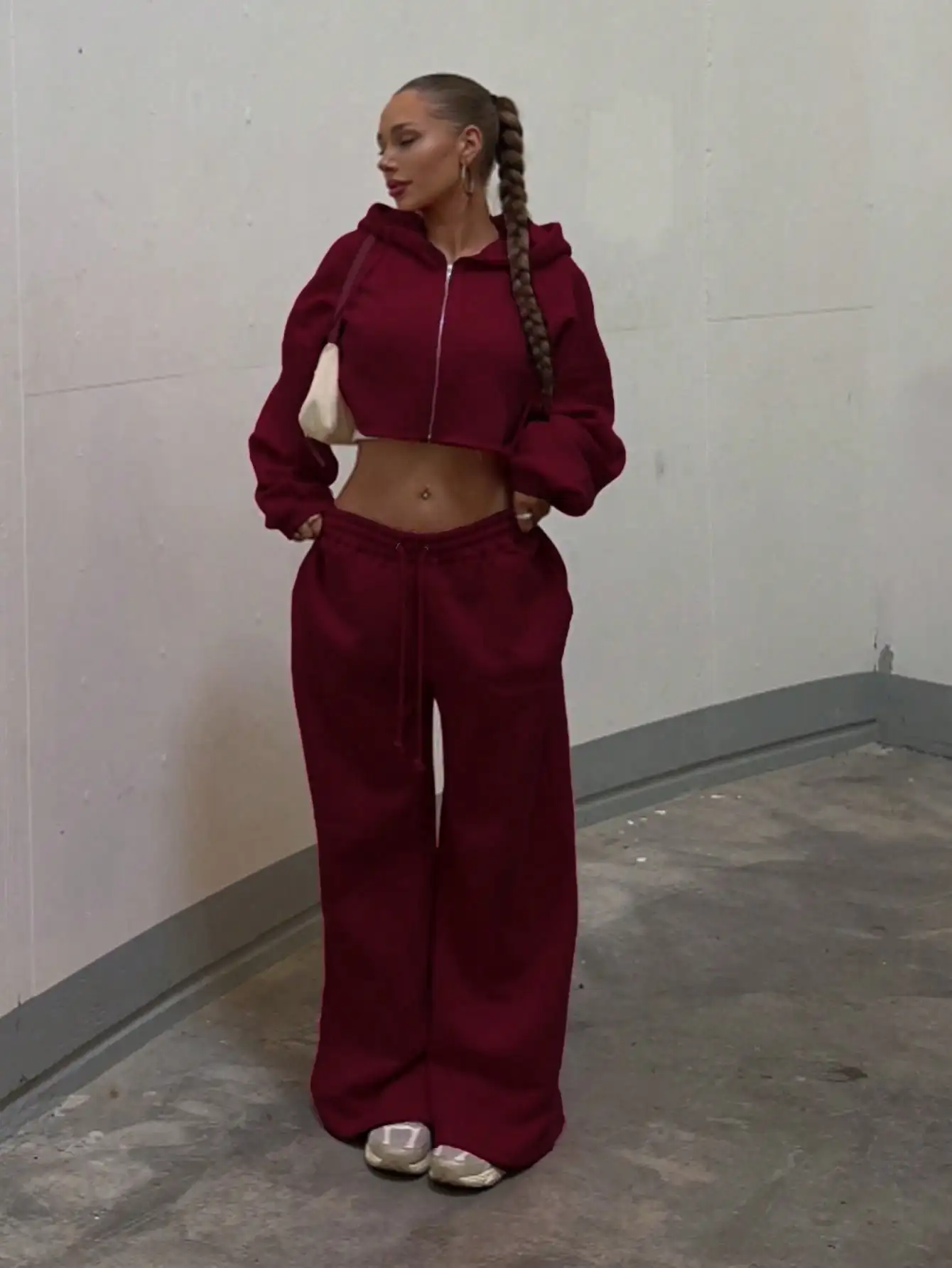 

Женский комплект: укороченное худи бордового цвета и широкие спортивные брюки, повседневный уличный костюм с молнией и шнурком
