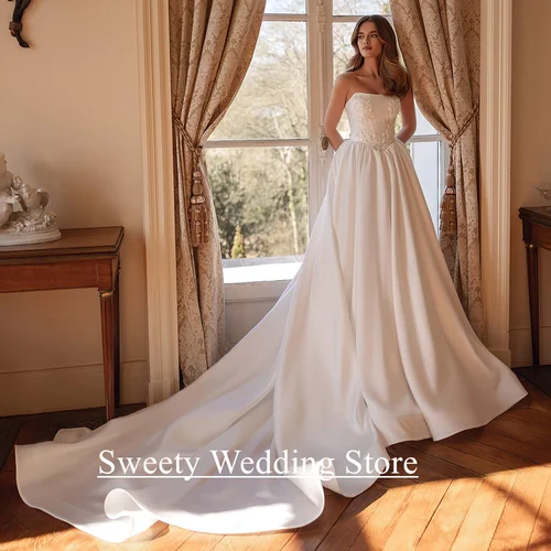 Encantador vestido de novia vestido de novia personalizado sin tirantes sin mangas apliques de cuentas una línea capilla tren vestidos de novia de satén