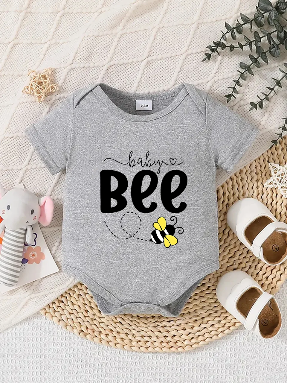 Playful letter-printed baby short-sleeve triangle bodysuit. Button closure for easy dressing, machine washable