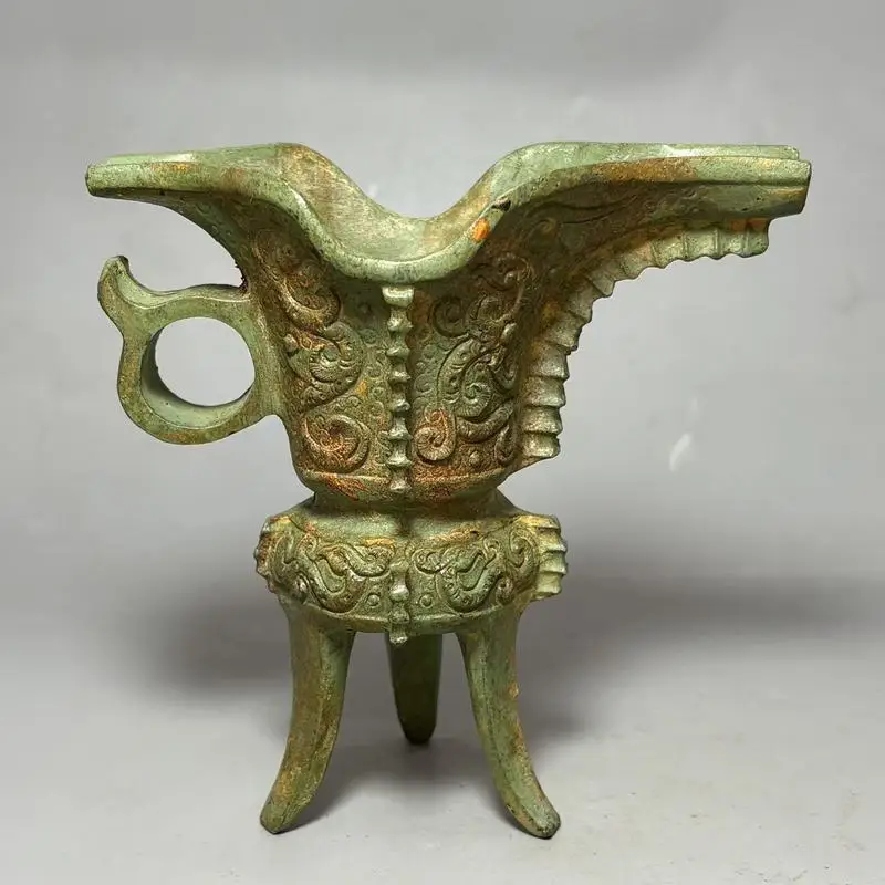 An unearthed green-rust patinaed Shang Dynasty three-legged wine cup with auspicious beast carvings, specially designed for king