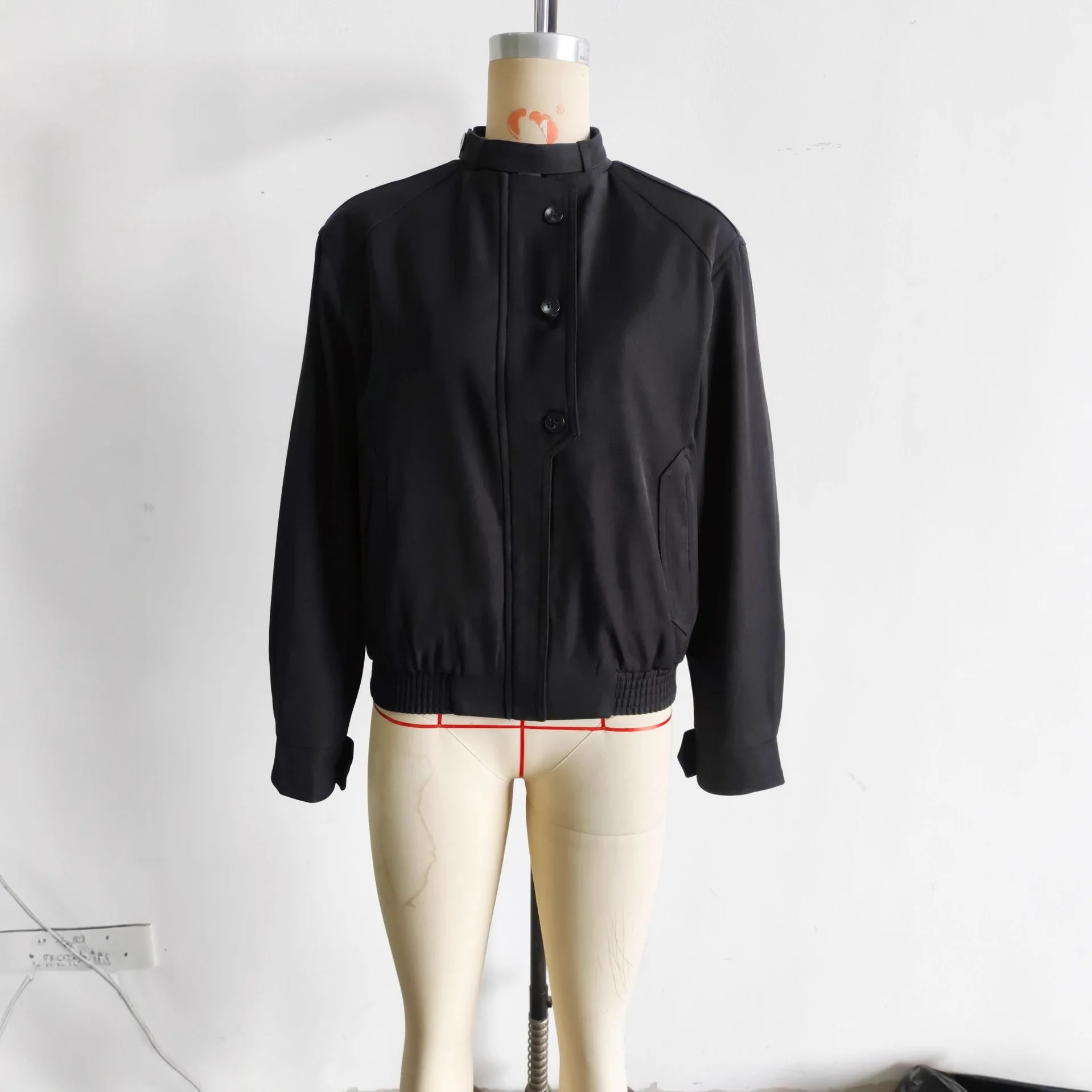 Jesienna moda: luźny płaszcz damski z dwukolorowymi guzikami, casualowy, zapinany na zamek, z wysokim kołnierzem i kieszeniami.