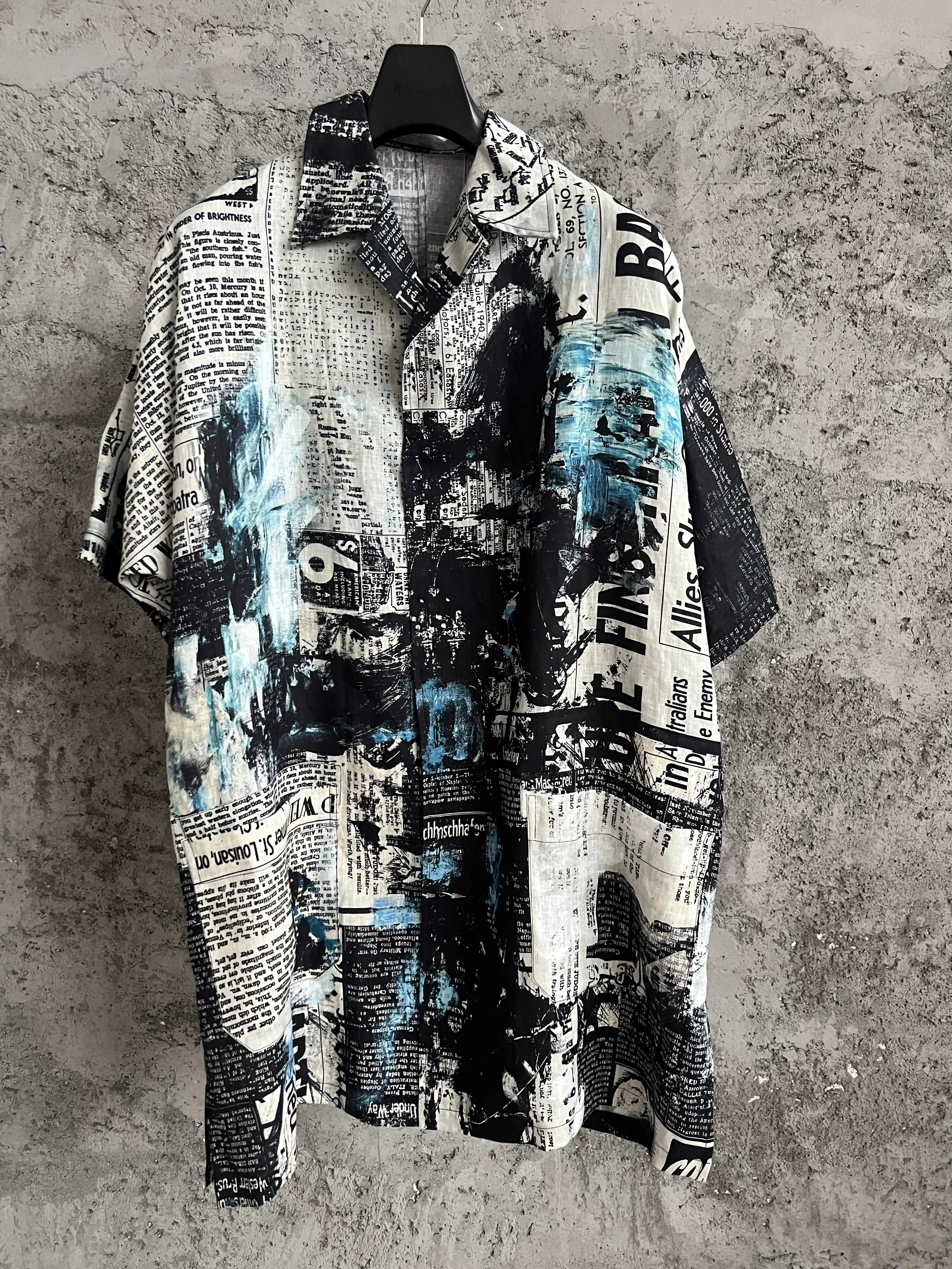 This all-cotton newspaper gun print short-sleeved open-collar shirt has a loose silhouette and is a niche men's three-quarter sl