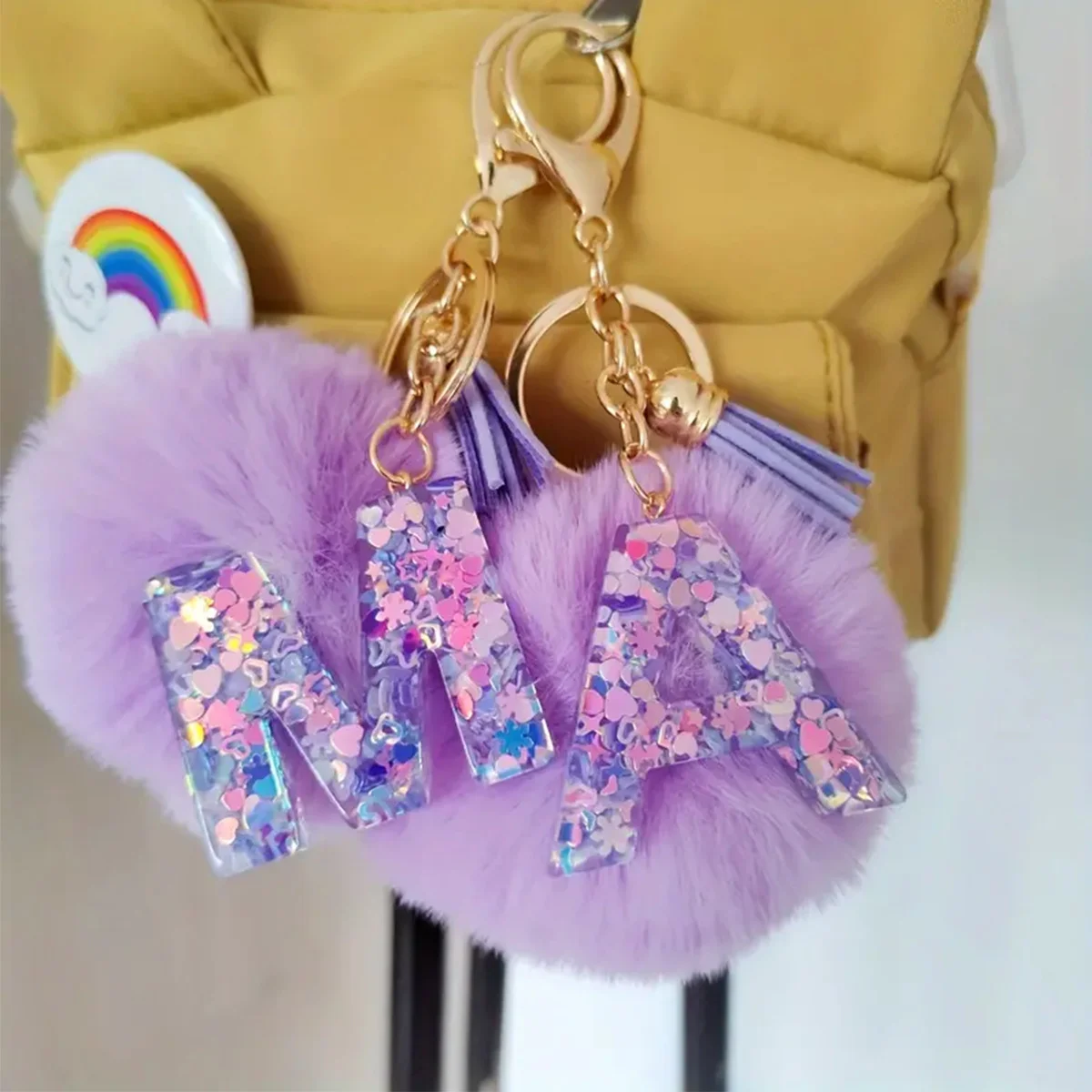 LLavero con iniciales brillantes y moradas, colgante de letra de resina con flecos y bolas de pelo, llavero de coche para niñas, bolso, mochila, accesorios