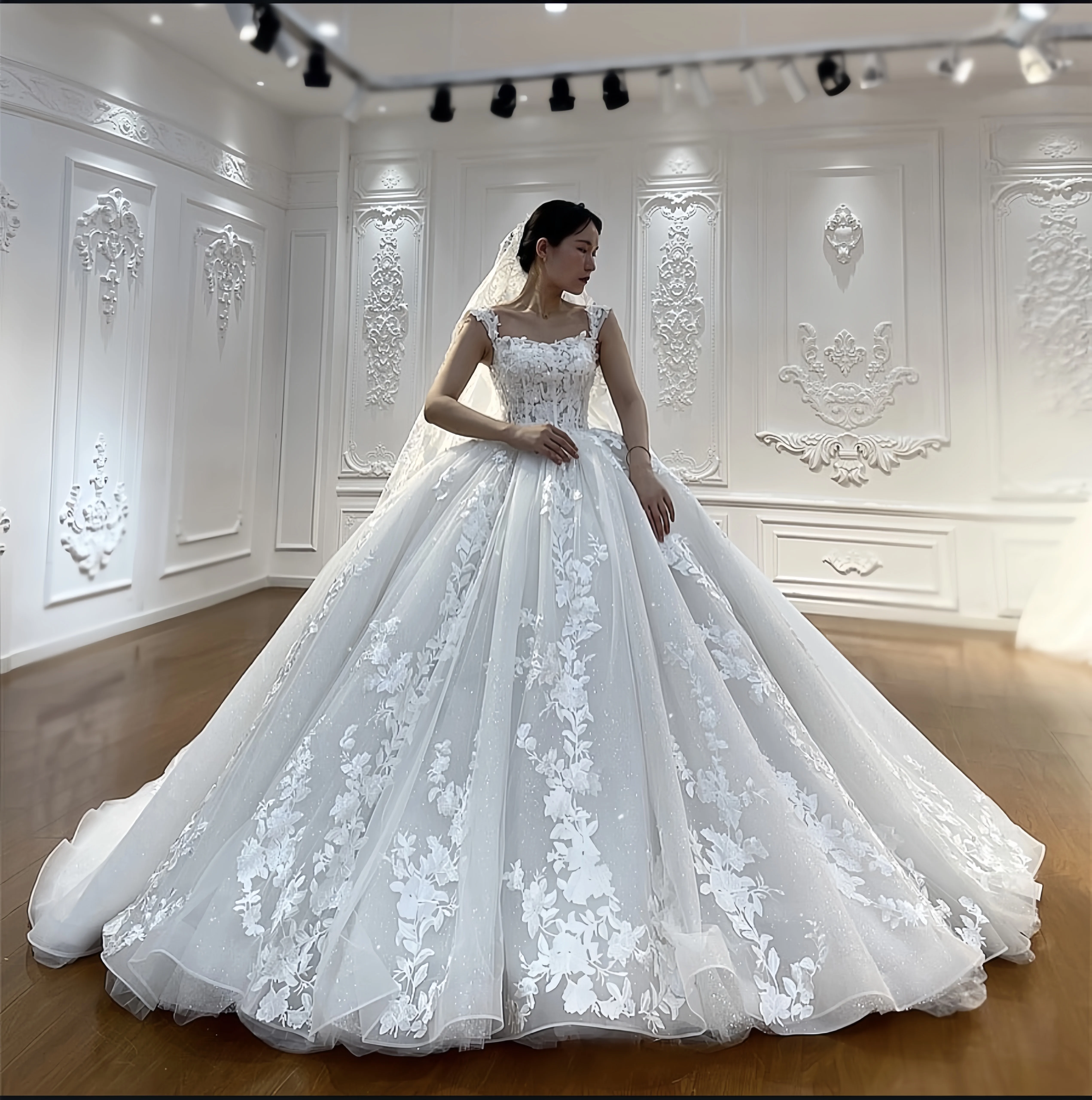 Customized luxurious wedding dress with three-dimensional appliqués, square neckline, fitted bodice, lace sleeves and fluffy ski