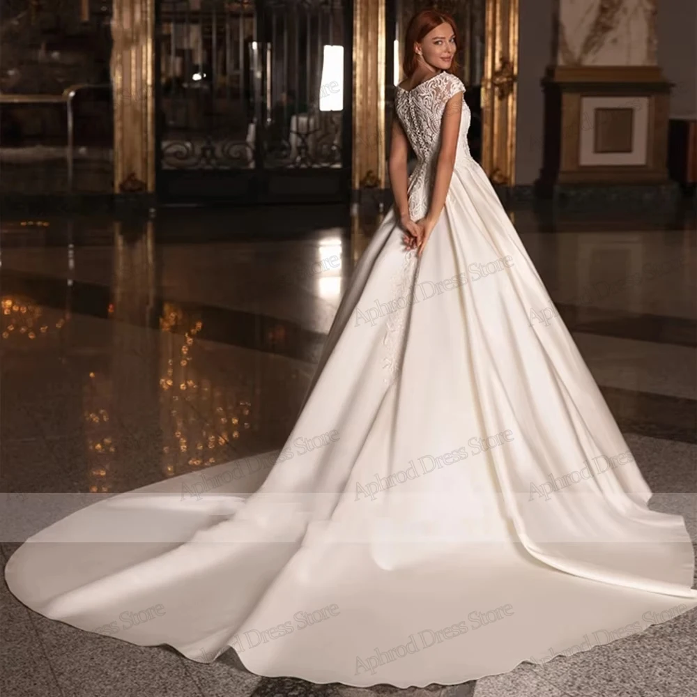 Robes De mariée glamour une ligne Robes De mariée en Satin dentelle Appliques sans manches Robes gracieuses robes De Novia personnalisées 2026