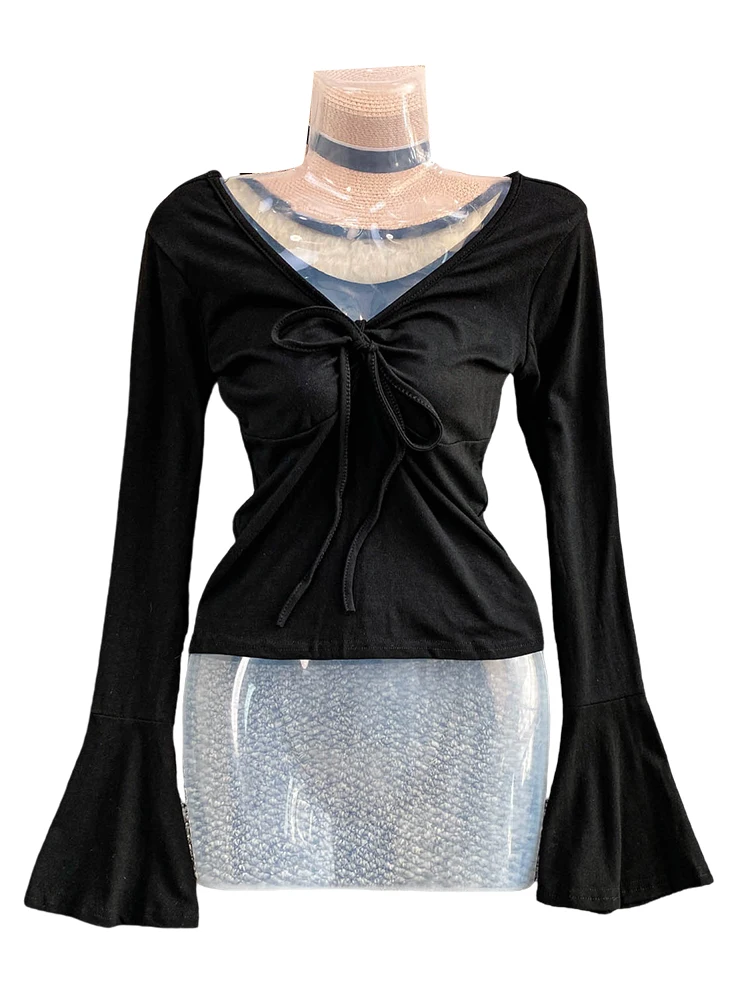 Seksowna, pikantna dziewczyna w dzianinowym, długim swetrze z dekoltem w serek, paskiem, wyszczuplającym krojem i dzwonkowymi rękawami, casualowy styl na jesień, moda damska.