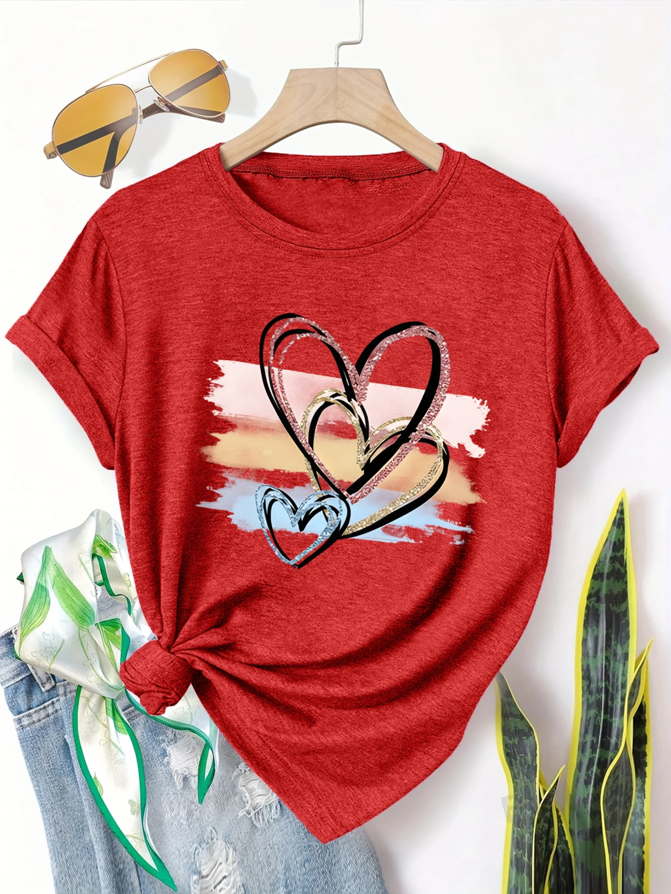 

Женская футболка больших размеров с короткими рукавами и цветным фоновым принтом в виде сердечек. Удобный и универсальный стиль на каждый день, летний вариант.