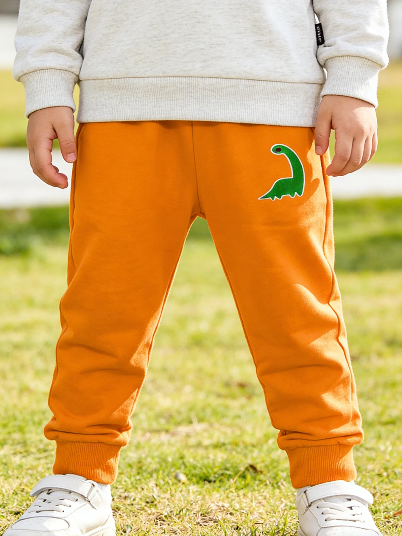 Pantalones deportivos con estampado de dinosaurios naranja para niños, pantalones deportivos de punto de poliéster para niños, pantalones casuales versátiles de cintura elástica para uso diario, 2-12T