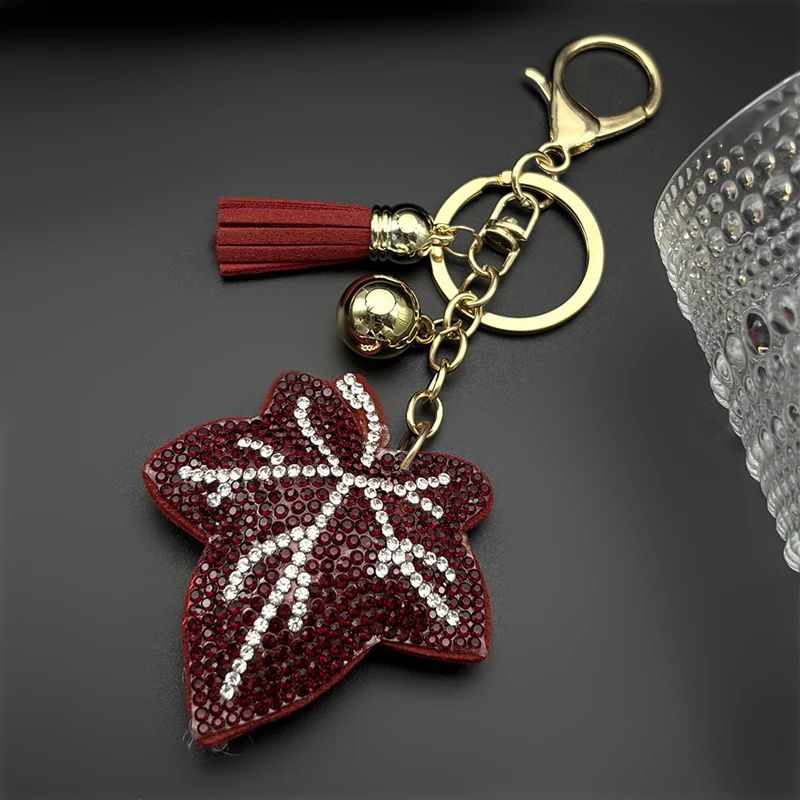 Porte-clés de luxe en forme de feuille d'érable pour femmes et hommes, avec strass en cristal brillant et pompon rouge, breloque de sac pour femme, cadeaux bijoux