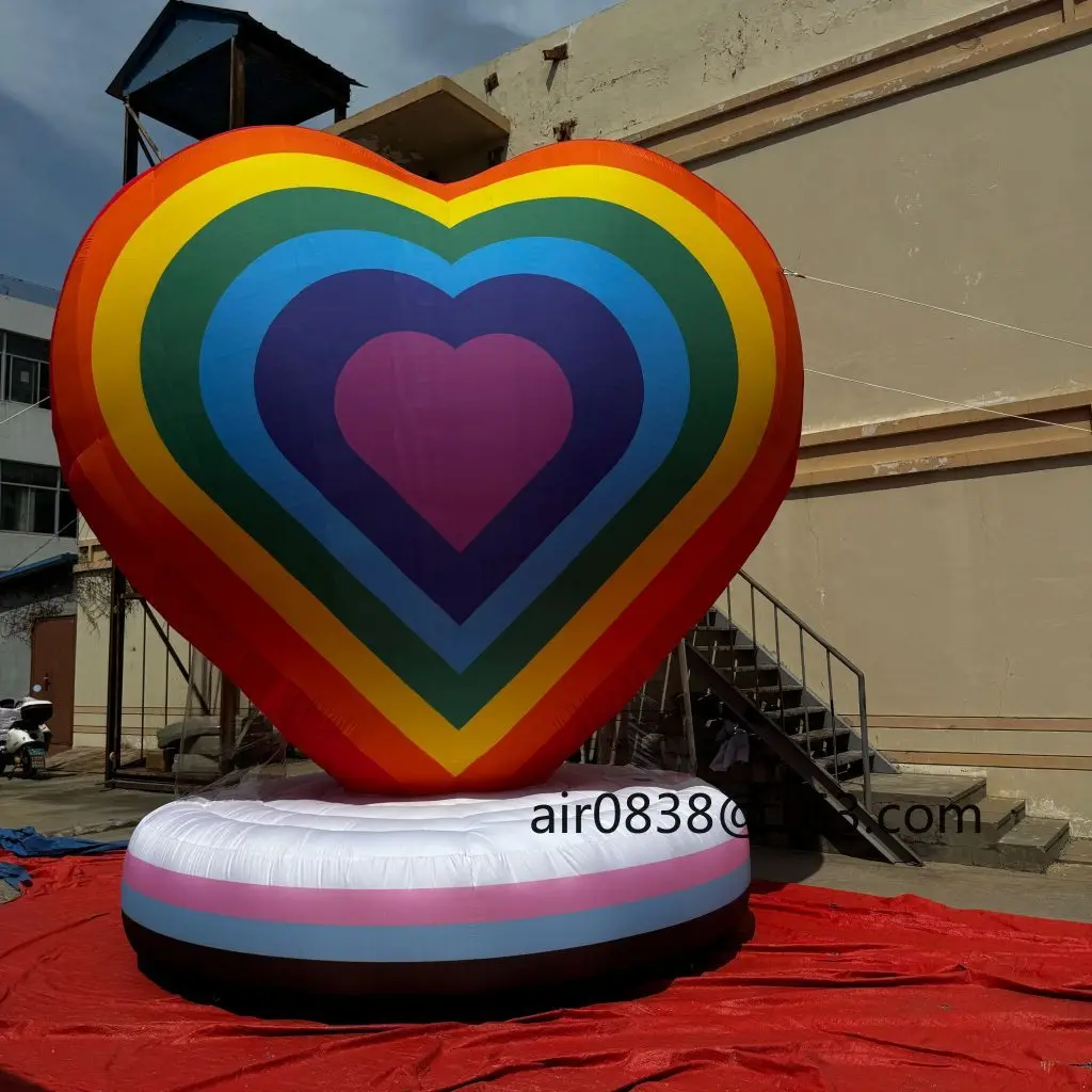 カラフルな虹色の膨らませるハート型、丸い台座付き巨大な膨らませるハート型モデル、結婚式パーティーイベントの装飾に