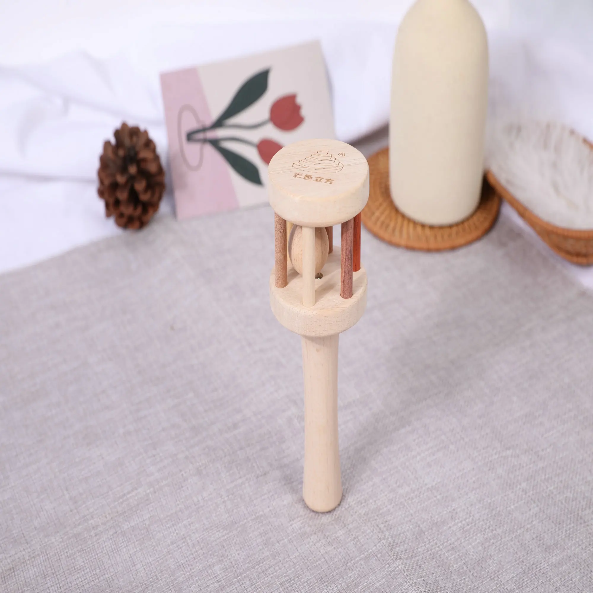 

A wooden handheld stand and an oval shaped ball form a vertical circular bell toy