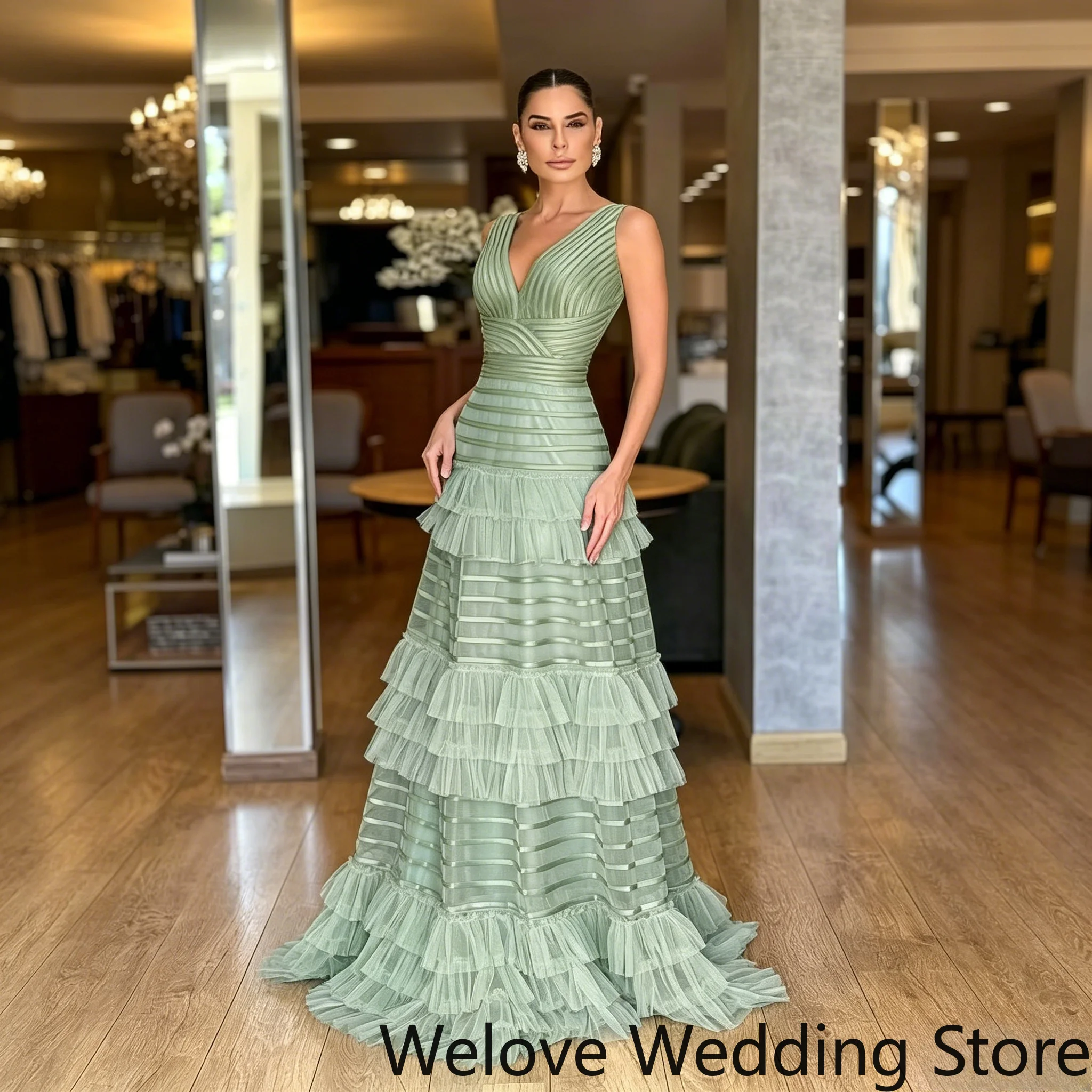 Sage Green Formal Evening Gown Featuring a deep V-neckline, structured pleated bodice, and voluminous tiered ruffle tulle skirt