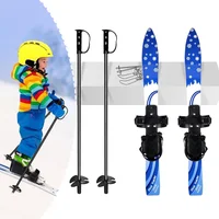 Children’s blue skis with bindings, adjustable ski poles and young skier for beginner snow activities