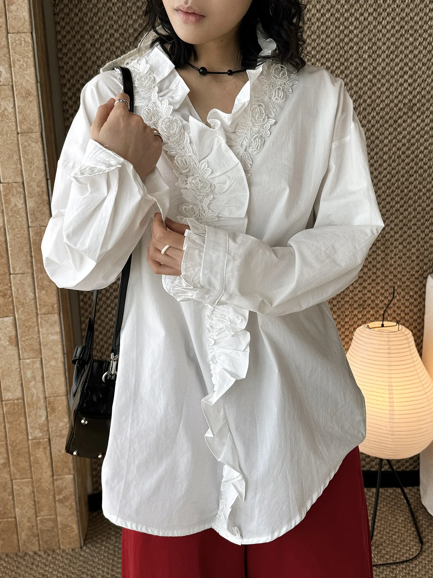 

Весенняя новинка: женская блузка свободного кроя с объемными бусинами и розовыми краями, декорированная вышивкой.