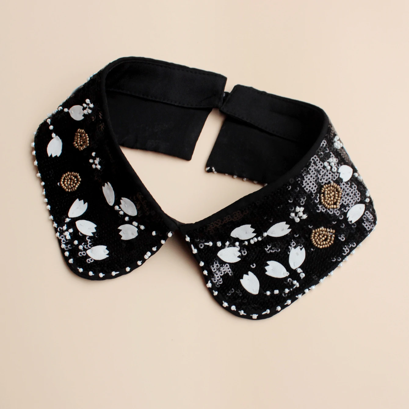 Fashion accessory, luxurious sequined false collar. Classic black background with white flowers. Inlaid with shining bead orname