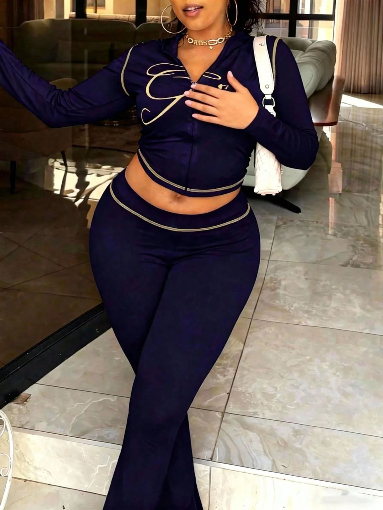 

Женский спортивный костюм из двух предметов: укороченный топ на молнии и брюки-клеш