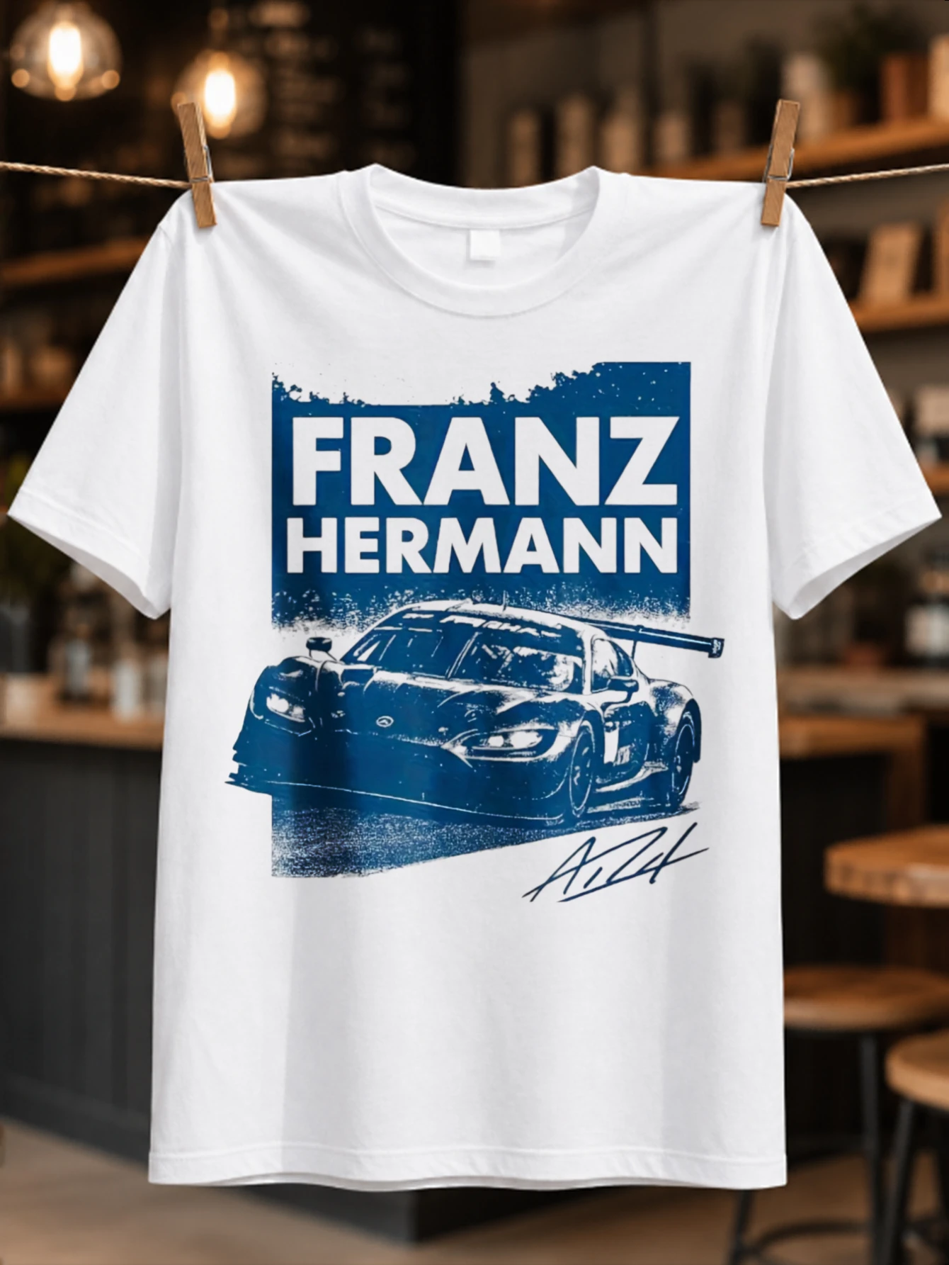 T-shirt unisexe avec graphique de voiture de course bleue de Franz Hermann Race Car, motif grunge, nom en blocs audacieux et signature.