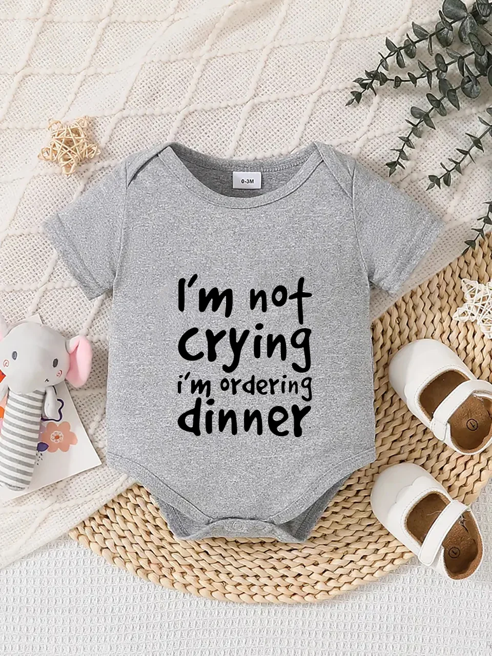 Playful letter-printed baby short-sleeve triangle bodysuit. Button closure for easy dressing, machine washable