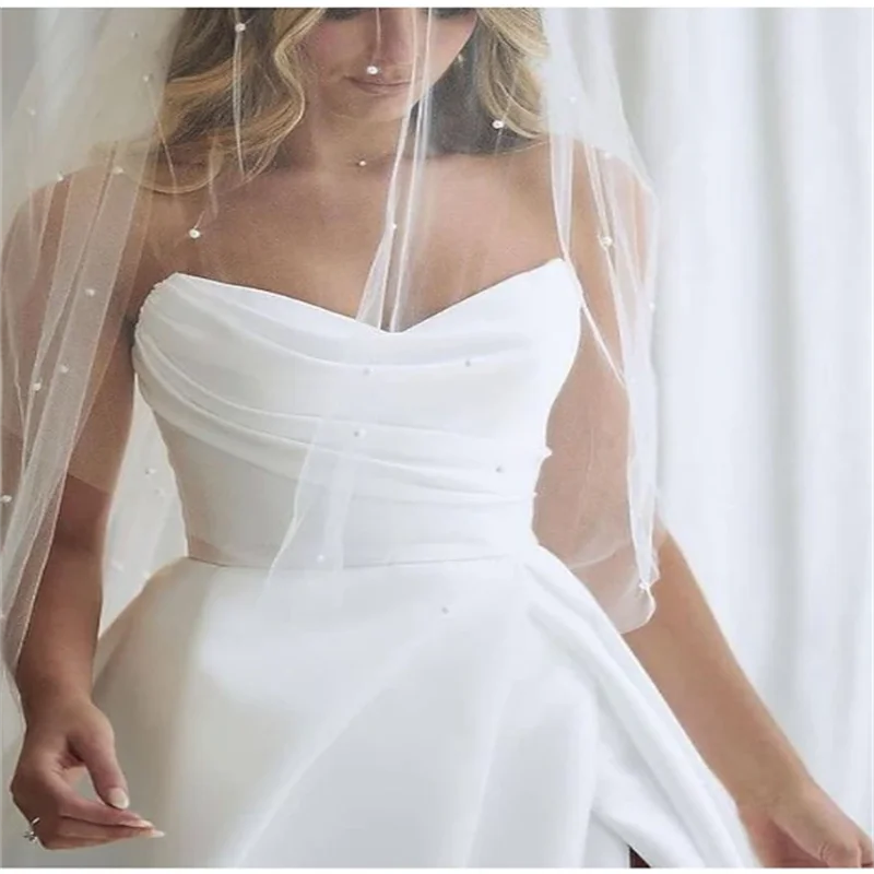 Maßgeschneiderte Falten-Prinzessin-weiße Brautkleider 2026 für die Braut, trägerloses, ärmelloses Damen-Ball-Brautkleid aus Satin mit Schleppe