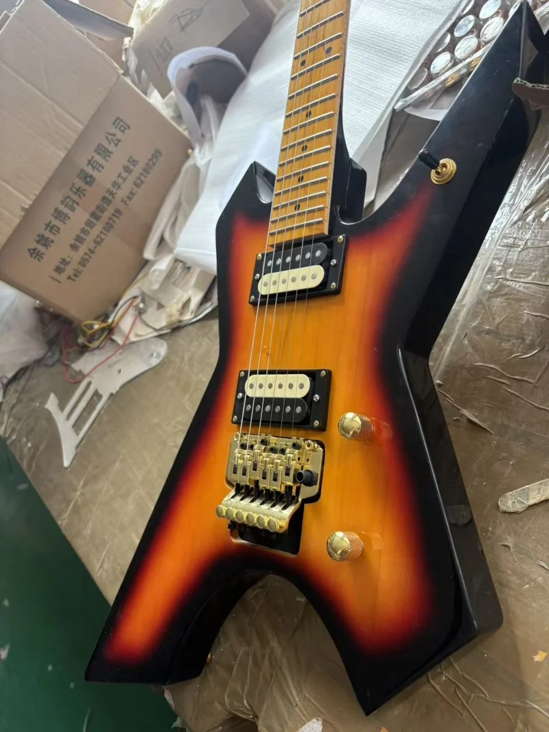Free delivery of a 6-string guitar with an unconventional shape, maple neck and fretboard, zebra pickups, and tremolo bridge.