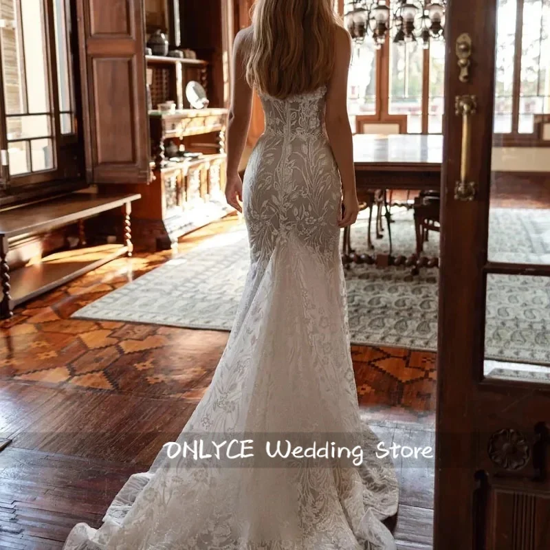 Suknia ślubna w stylu syreny, seksowna, pełna wdzięku, z dekoltem w serduszko, z tiulu w kolorze ecru, z odpinanym trenem.