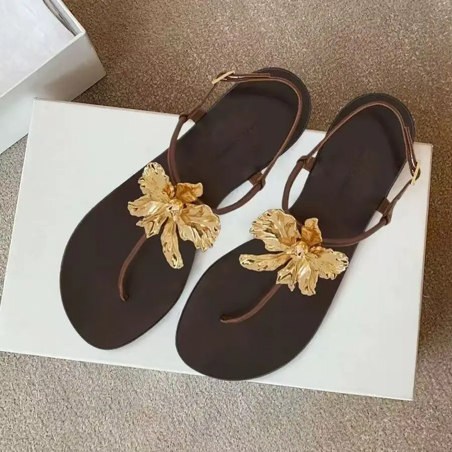 Neue Damen-Slipper mit T-Riemen, modische, weiche, flache Sandalen mit niedrigem Absatz und Metallblume, Outdoor-Sommer-Flip-Flops in Schwarz und Braun