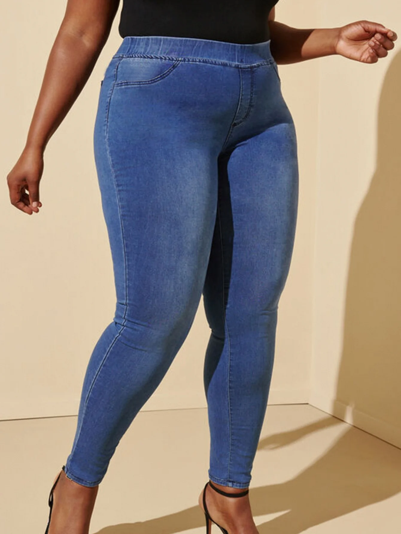 Dżinsy plus size, codzienne, elastyczne, z niebieskiego denimu, z gumką w pasie, o długości cropped, odpowiednie dla kobiet w okresie wakacji.