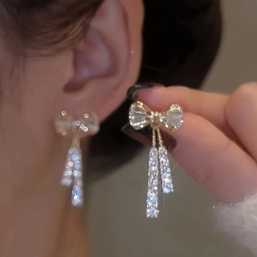 Un par de delicados pendientes con forma de lazo y circonitas cúbicas brillantes, hechos con elegantes piedras preciosas sintéticas engastadas en una aleación pulida brillante, perfectos como regalo para cumpleaños, aniversarios o el Día de San Valentín para mujeres y damas.