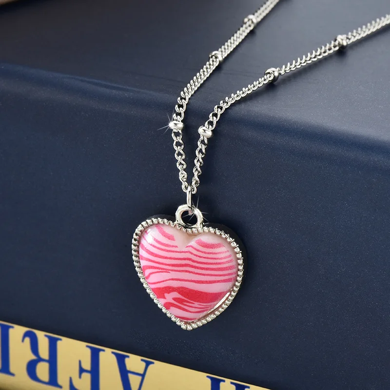 

A hot girl wearing a pink zebra striped heart-shaped necklace, a versatile collarbone chain, and a fashionable lady's necklace