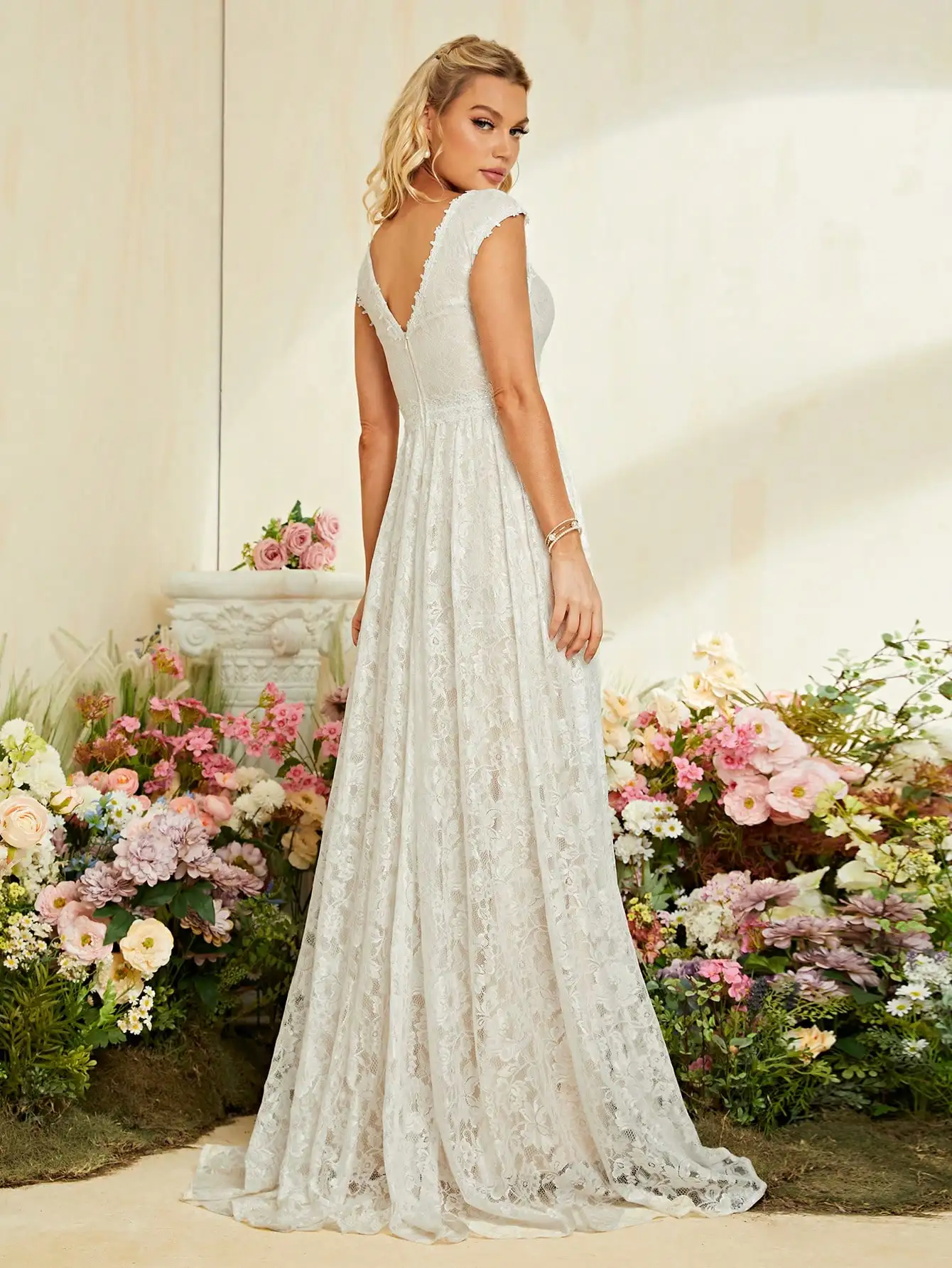 Suknia ślubna z dekoltem w kształcie litery V, zdobiona cekinami i koronką.