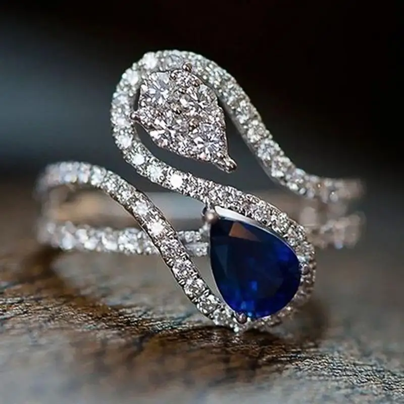 Huitan Damenring mit geometrischem Design, Kurvendesign mit weiß/blauem Zirkonia, zierliche Accessoires für Party, Hochzeit, eleganter Schmuck, trendiger Schmuck