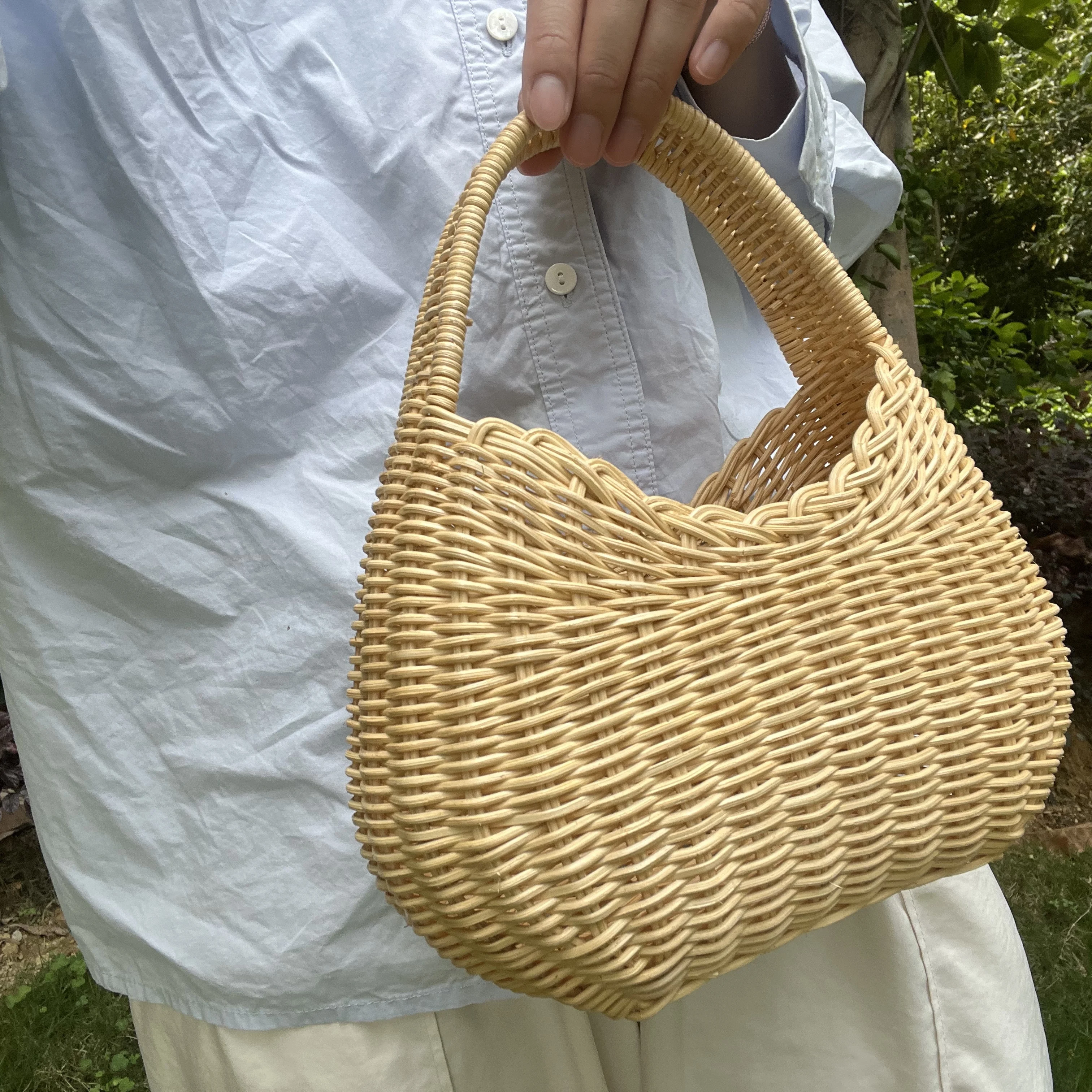 The same handmade rattan three-dimensional bag from a luxury brand has a handle that can be carried by hand