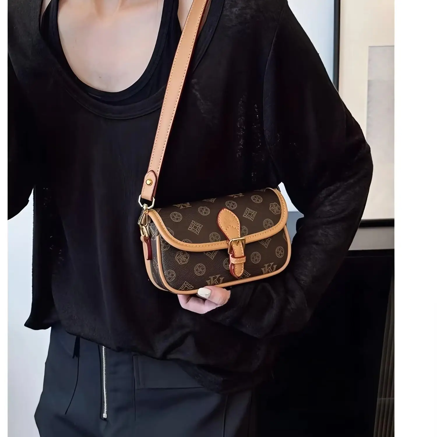 Dark brown all-over printed small rectangular handbag with contrasting brown leather trim and a single shoulder strap.