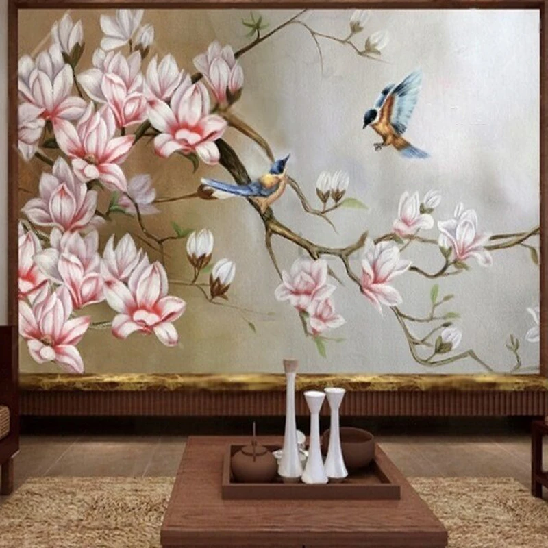 A custom TV background wall featuring hand-painted flowers birds and magnolias in Chinese ink wash style