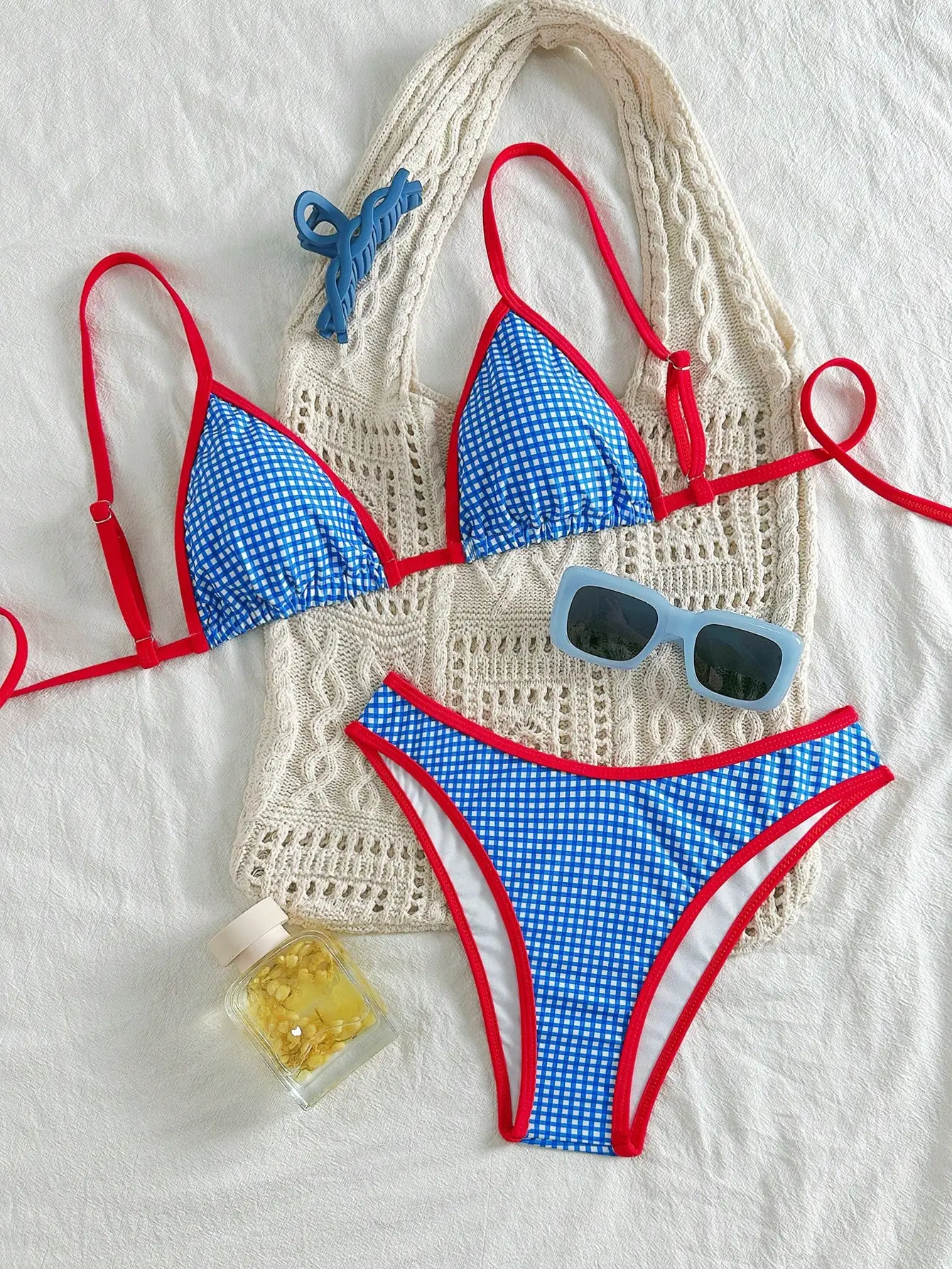 

Синий комплект бикини с принтом в клетку, красной контрастной отделкой, треугольным верхом и высокой посадкой на нижней части.