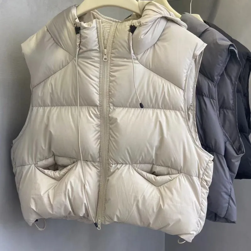 เสื้อกั๊กขนเป็ดแบบมีฮู้ดสำหรับฤดูใบไม้ร่วงและฤดูหนาว ทรงหลวม หนานุ่ม อุ่นสบาย เหมาะสำหรับผู้หญิง สีขาว ซิปหน้า ไม่มีแขน