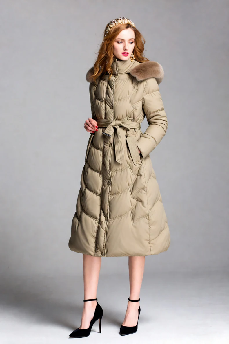 Piumino lungo trapuntato da donna con cappuccio in pelliccia e piumino d'anatra bianco in vita con cintura per il calore invernale e uno stile elegante