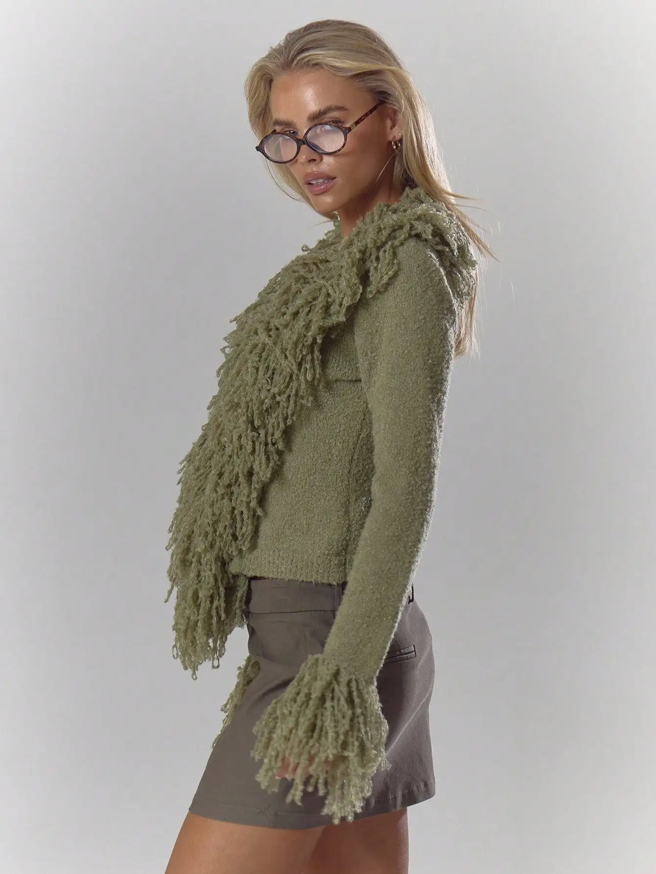 Kardigan w kolorze oliwkowej zieleni z puszystym wykończeniem i rękawami z frędzlami, idealny na jesień i zimę, zapewniający elegancję na co dzień.