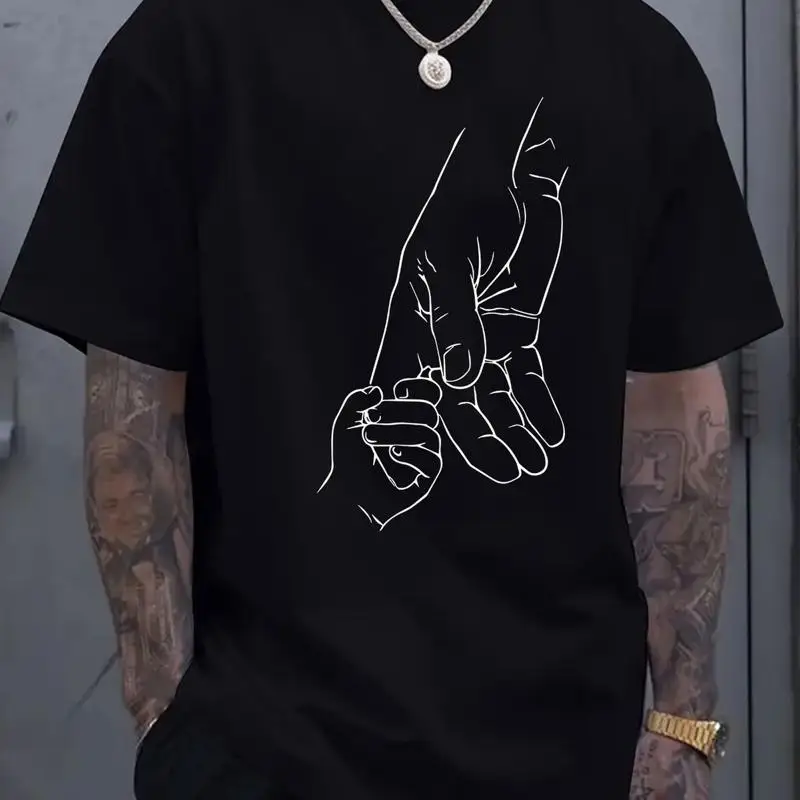 

Small hand holding large pattern printed men's round neck short sleeved T s shirt